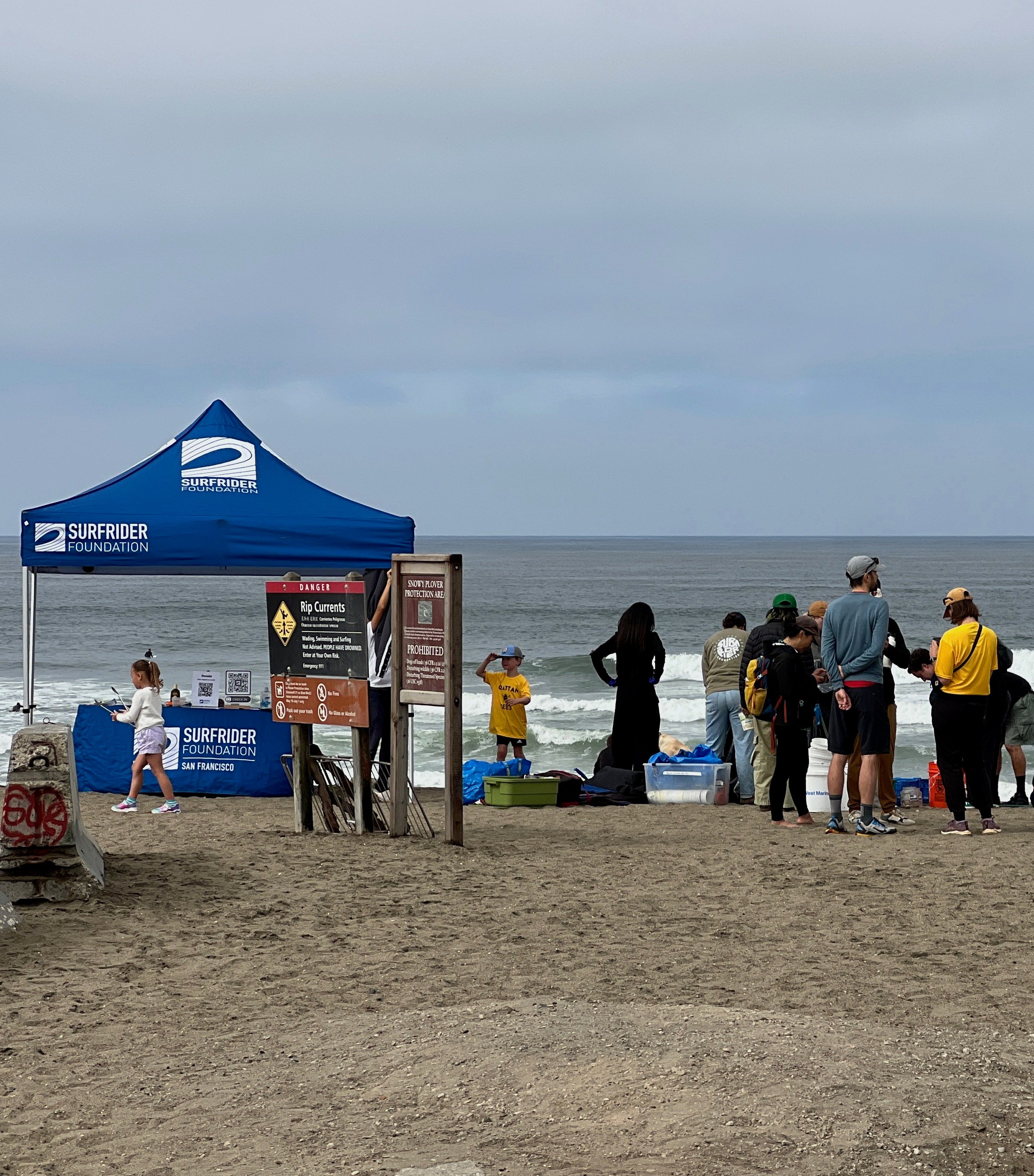 Surfrider tent and volunteers looking out toward the ocean