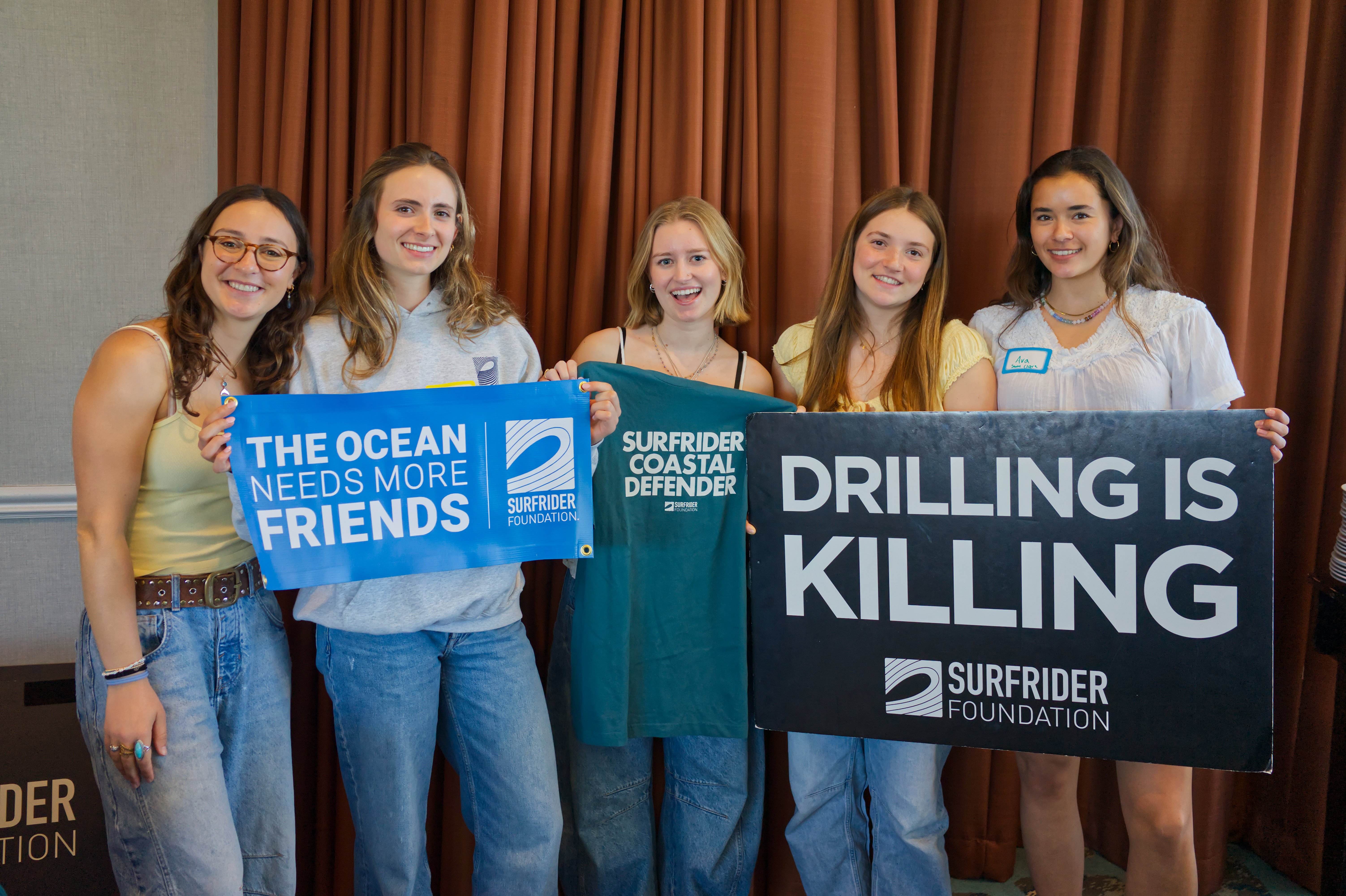 group posing with surfrider signs and shirt 