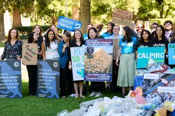 A crowd of policy leaders and activists gather at a press conference. 