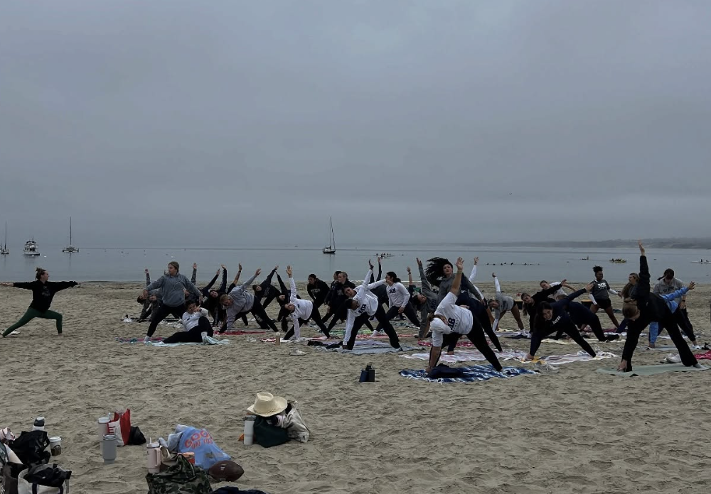 A group of people doing yoga on the beach