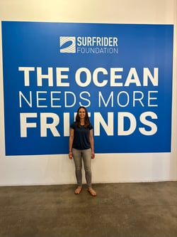 Woman standing in front of a wall that says "The Ocean Needs More Friends"